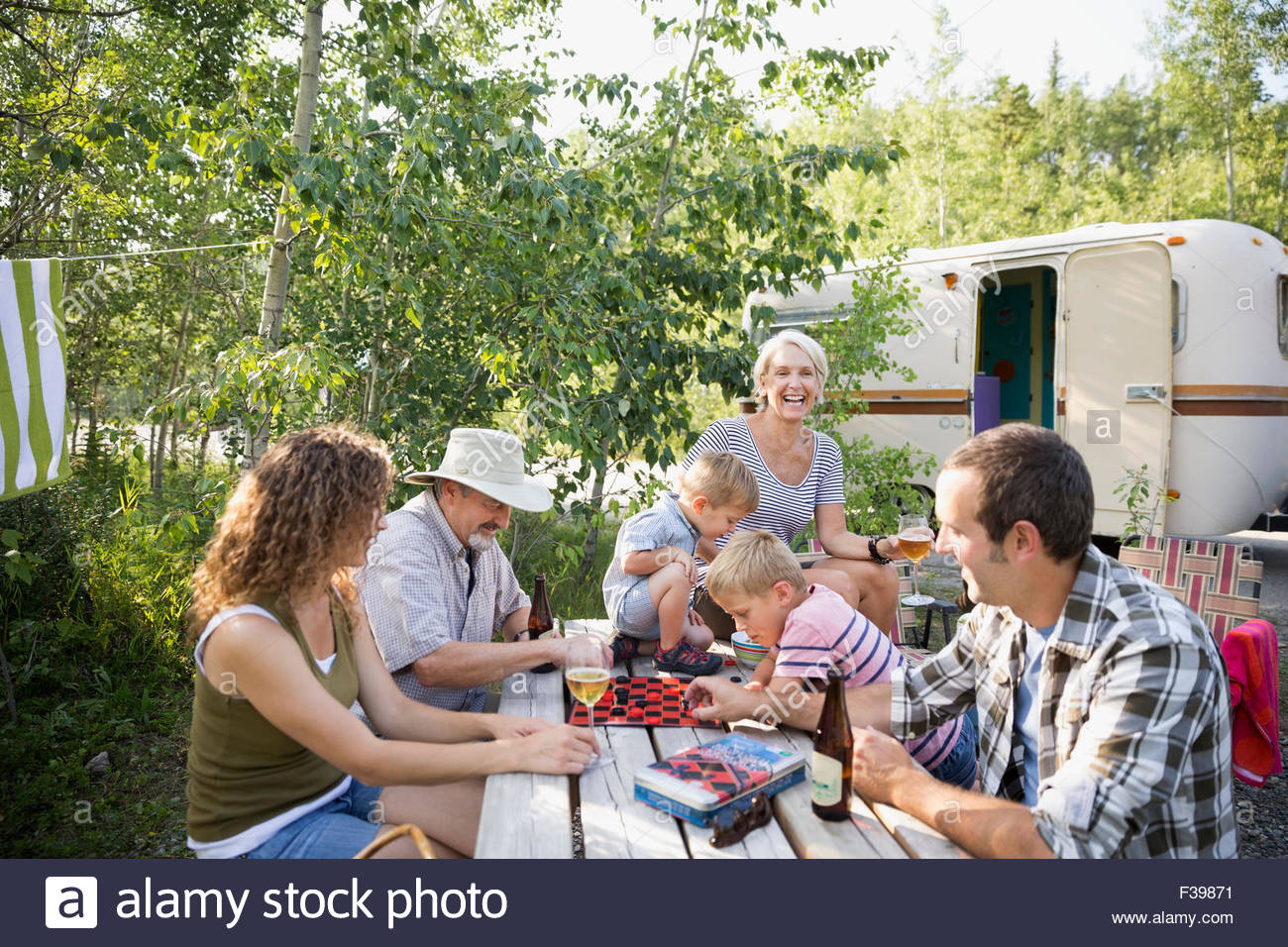 Multigeneration family playing checkers campsite picnic table Stock