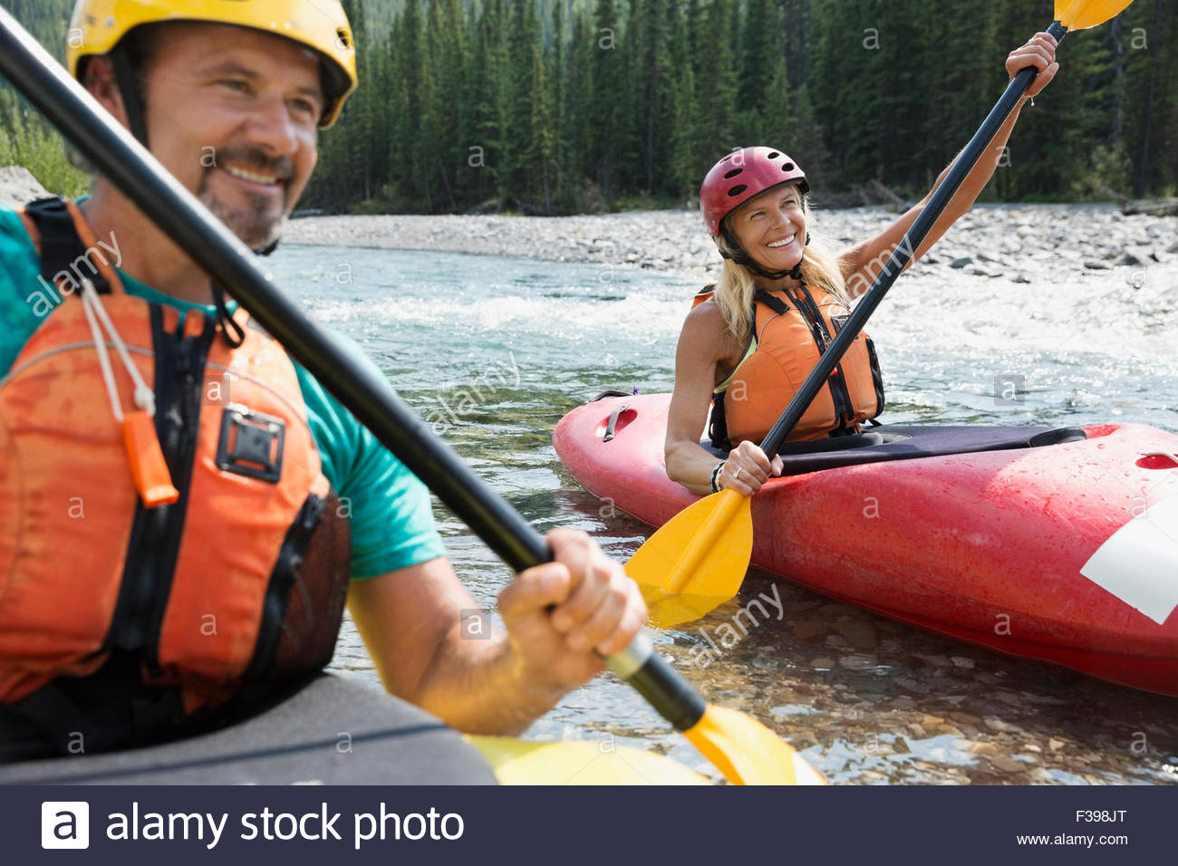 Smiling couple kayaking in river Stock Photo