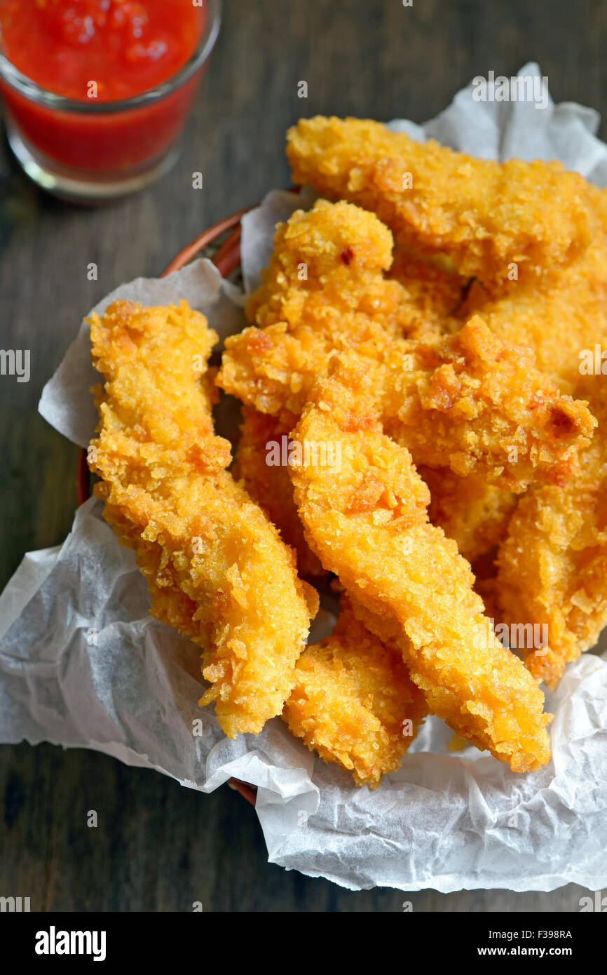 Crispy Chicken Fillets on old wooden table Stock Photo