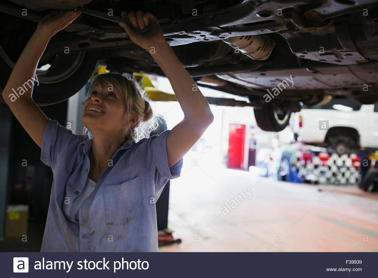 Female mechanic working underneath car auto repair shop Stock Photo Alamy