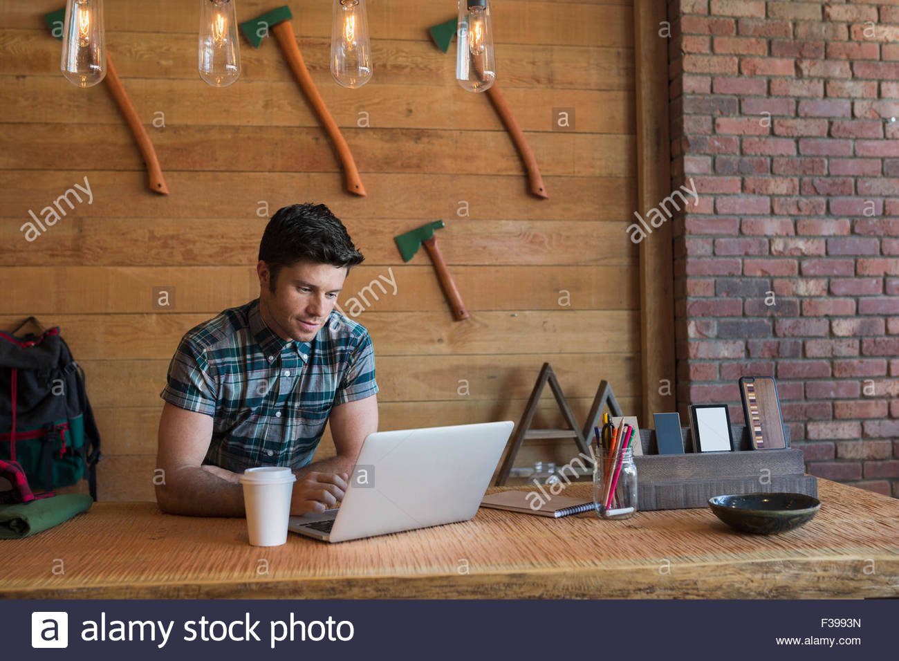 Business owner with coffee working at laptop Stock Photo