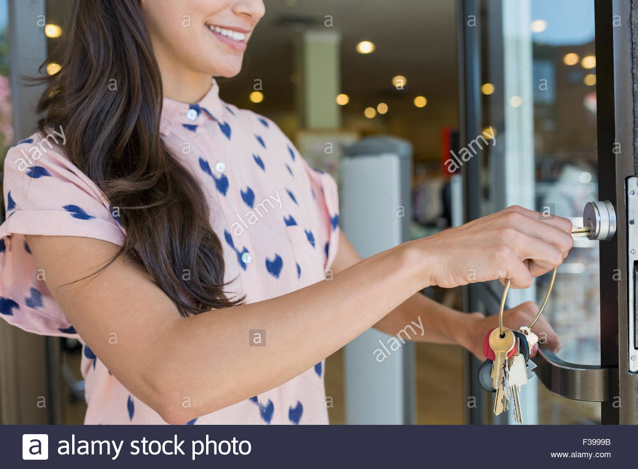 Business owner unlocking shop door with key Stock Photo