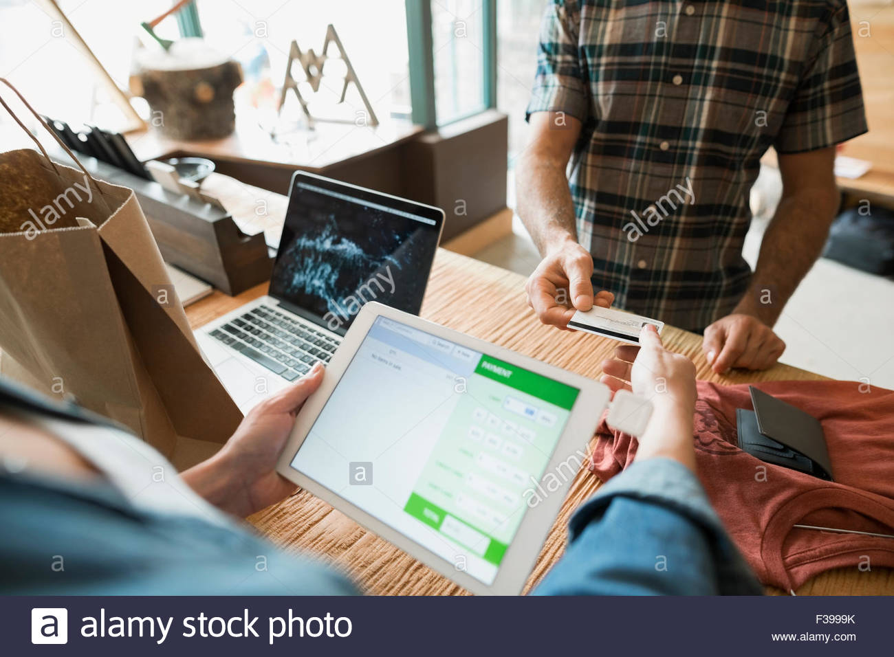 Customer with credit card paying worker digital tablet Stock Photo