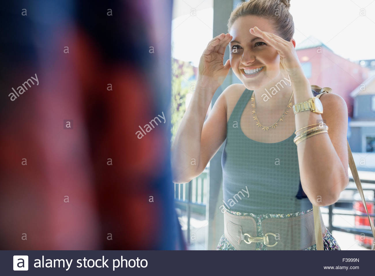 Enthusiastic woman peeking at shop window Stock Photo