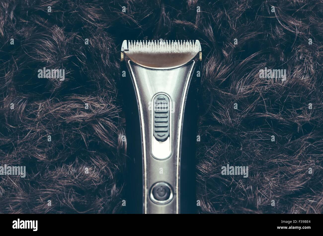 Electric hair trimmer with hair in the background. Stock Photo