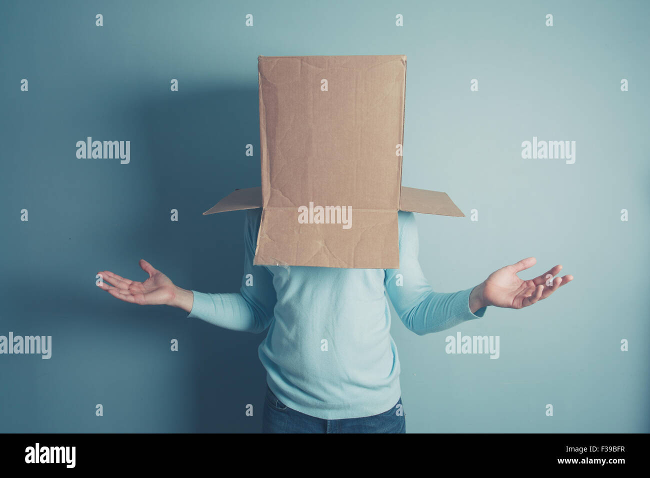 A confused man is standing with a cardboard box on his head Stock Photo ...