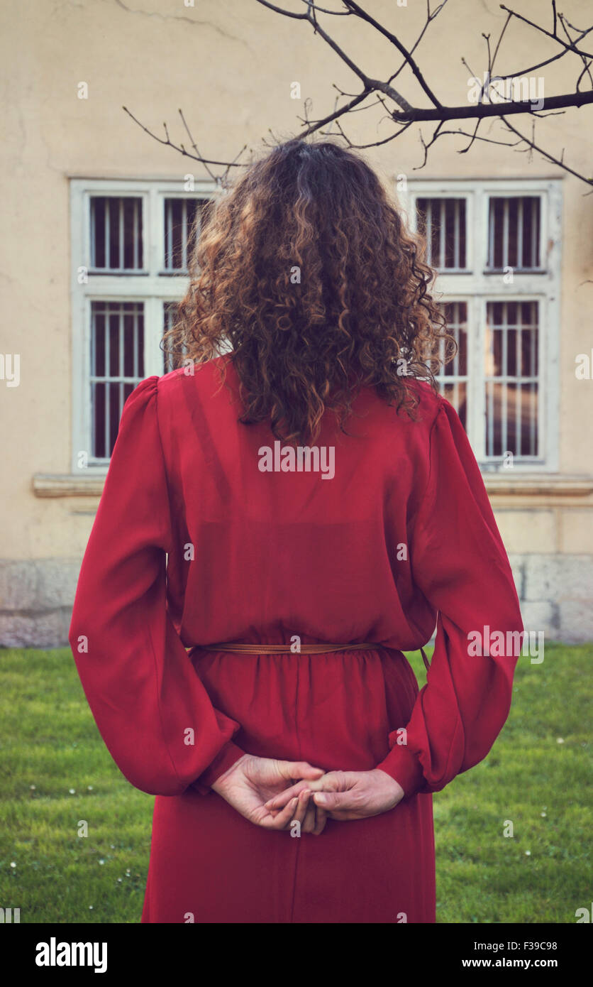 Woman in red dress standing outdoors, rear view Stock Photo - Alamy