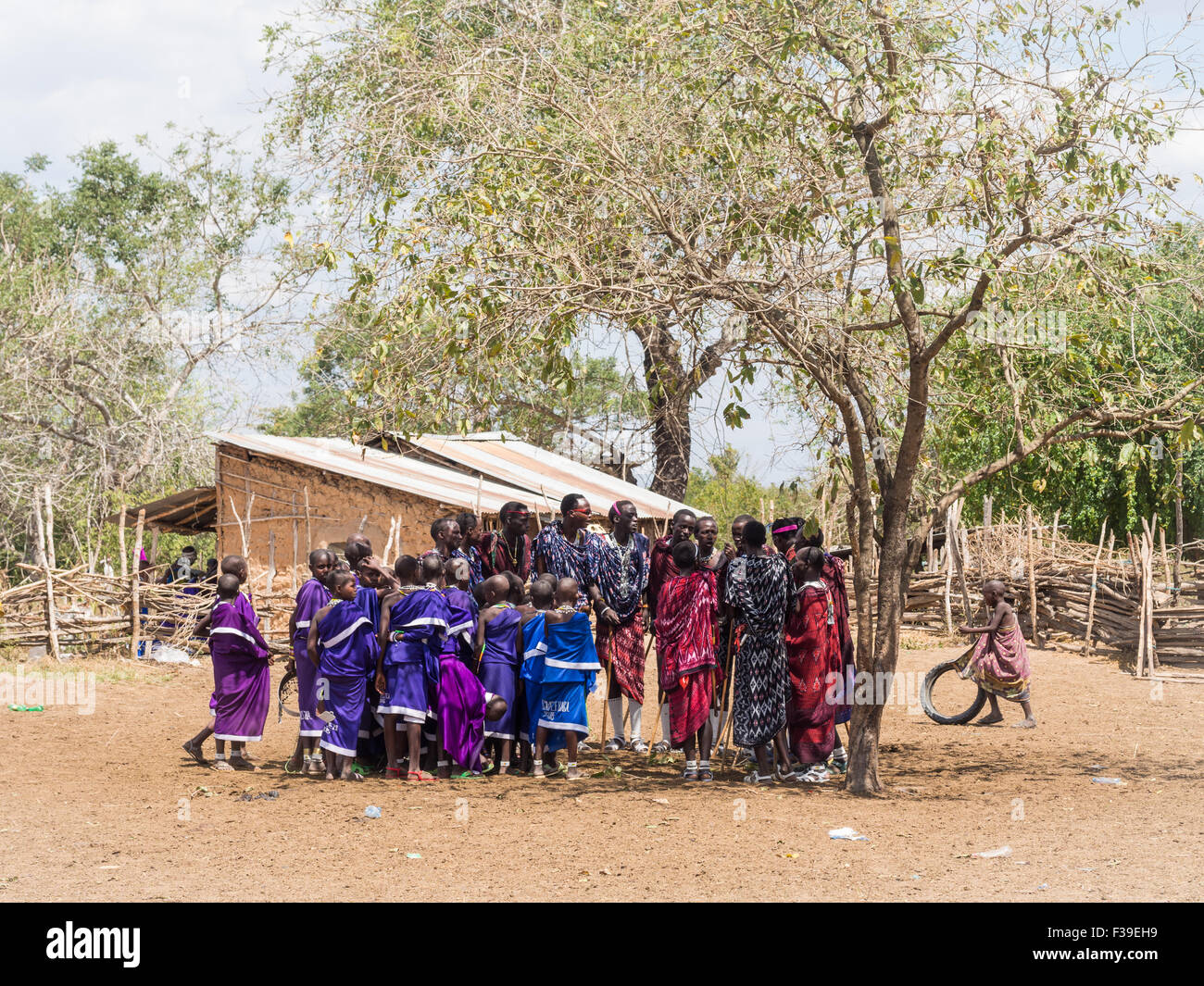 Maasai young man dancing and singing in a circle during the ceremony in a boma (Maasai village) Stock Photo