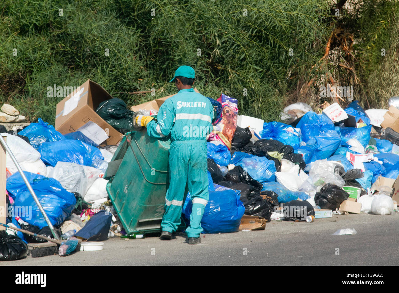 Beirut Lebanon. 2nd October 2015. An employee of the cleaning company Sukleen tips a bin of