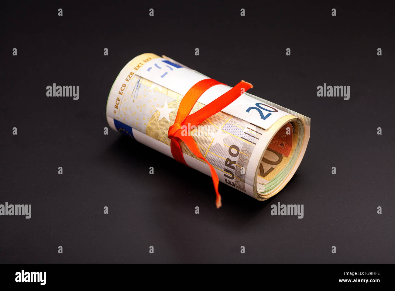 euro money in a red ribbon on black Stock Photo