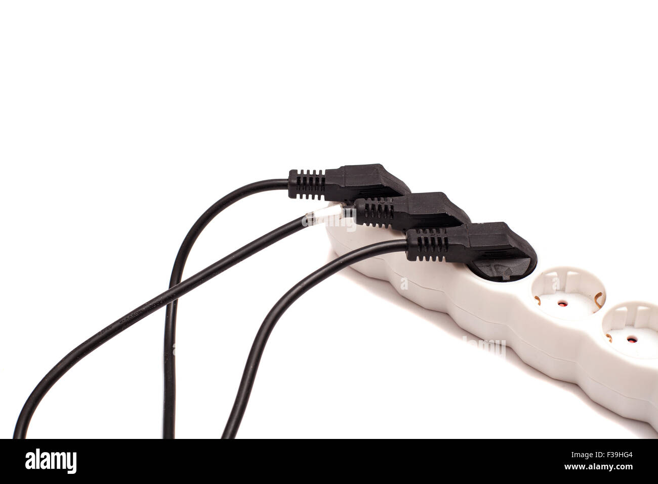 Many plugs plugged into electric power bar isolated on white Stock