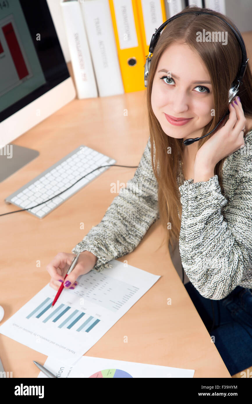 Young businesswoman with headset on in the office interior Stock Photo ...