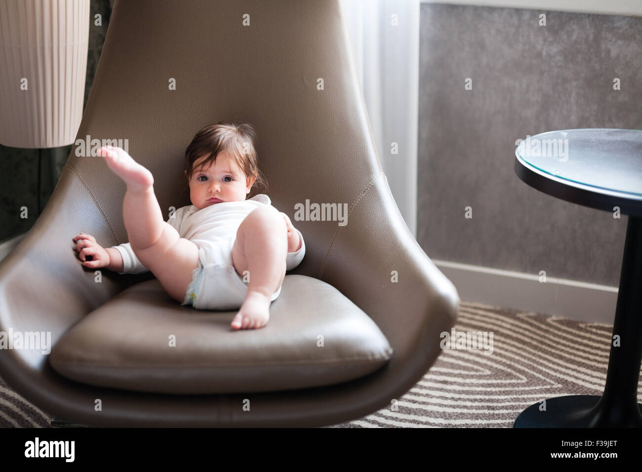 Six month old baby girl relaxing in a swivel chair Stock Photo Alamy
