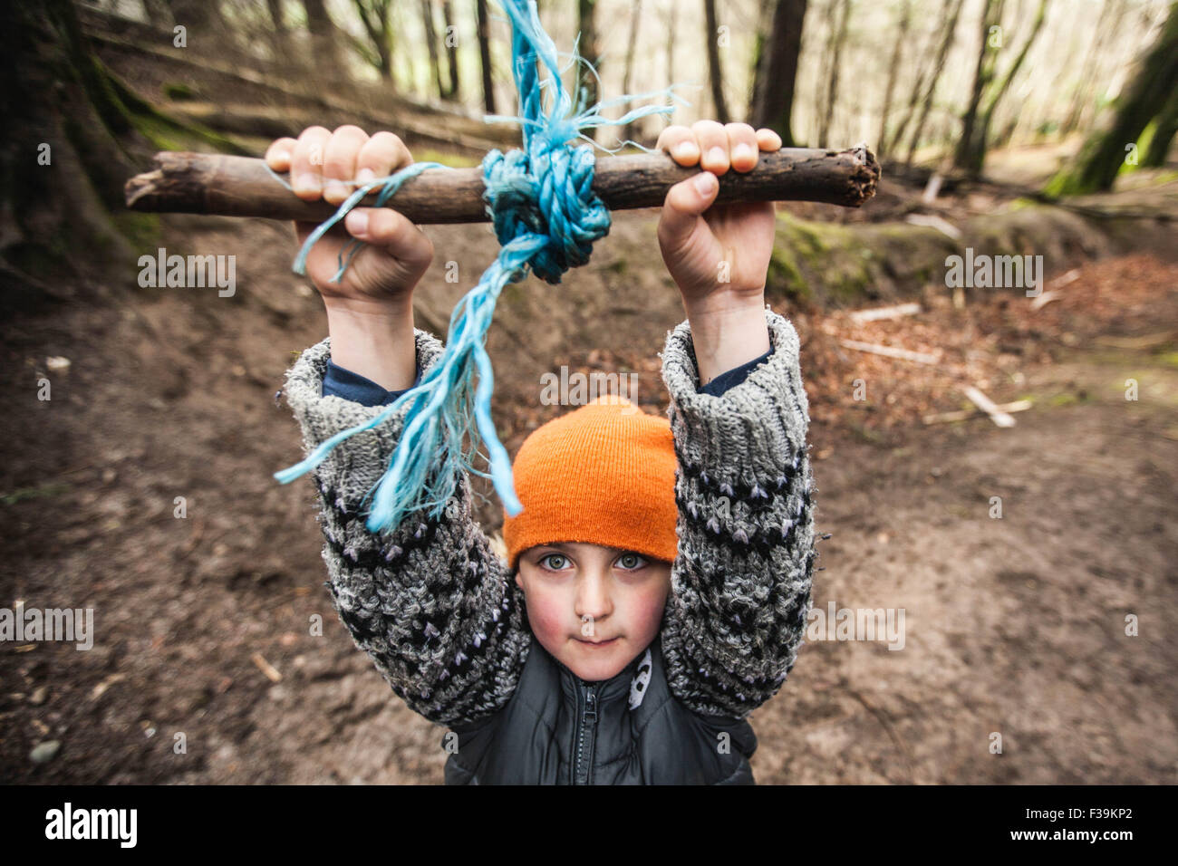 Boy playing hanging on a rope swing in the forest Stock Photo Alamy