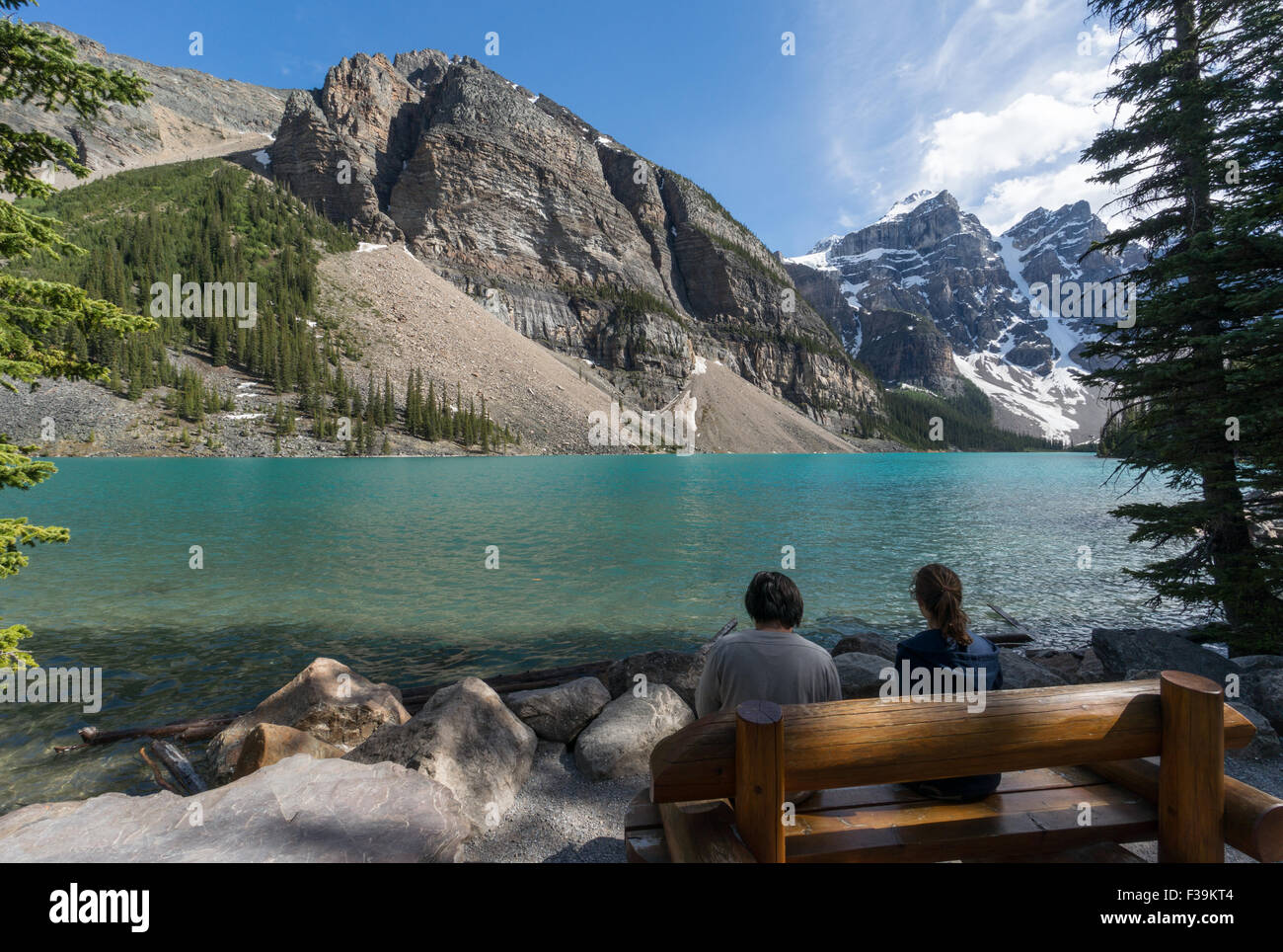 Two people sitting by Moraine Lake, Banff National Park, Canadian Rockies, Alberta, Canada Stock Photo