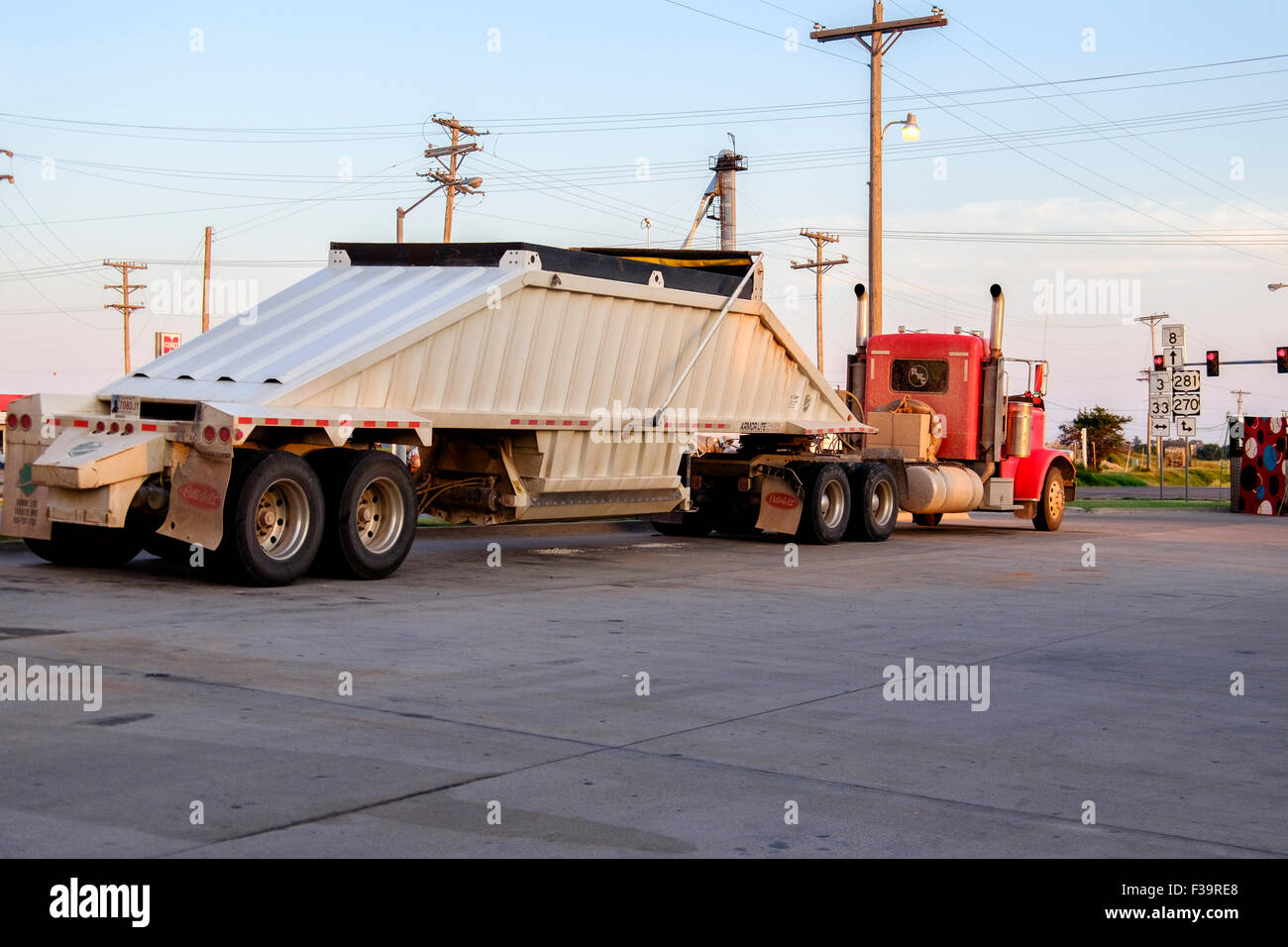 A semi truck parked in a parking lot in rural Oklahoma in evening golden light.. Stock Photo