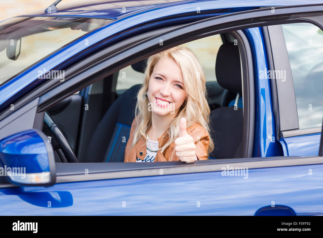 Beautiful happy young girl sitting in her car Stock Photo - Alamy