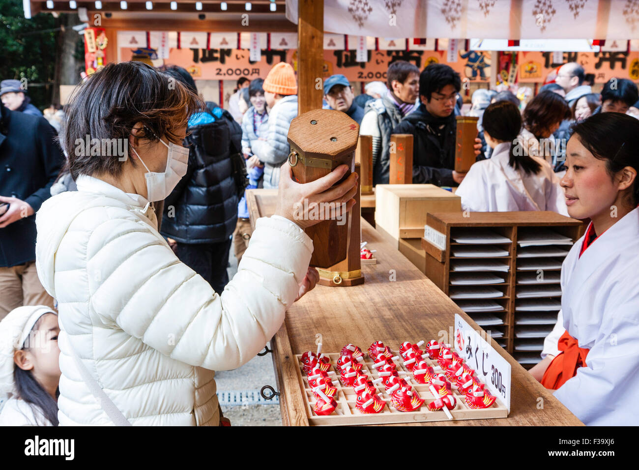 Japan, Nishinomiya shrine, New year Day, Shogatsu. Woman buying omikuji ...