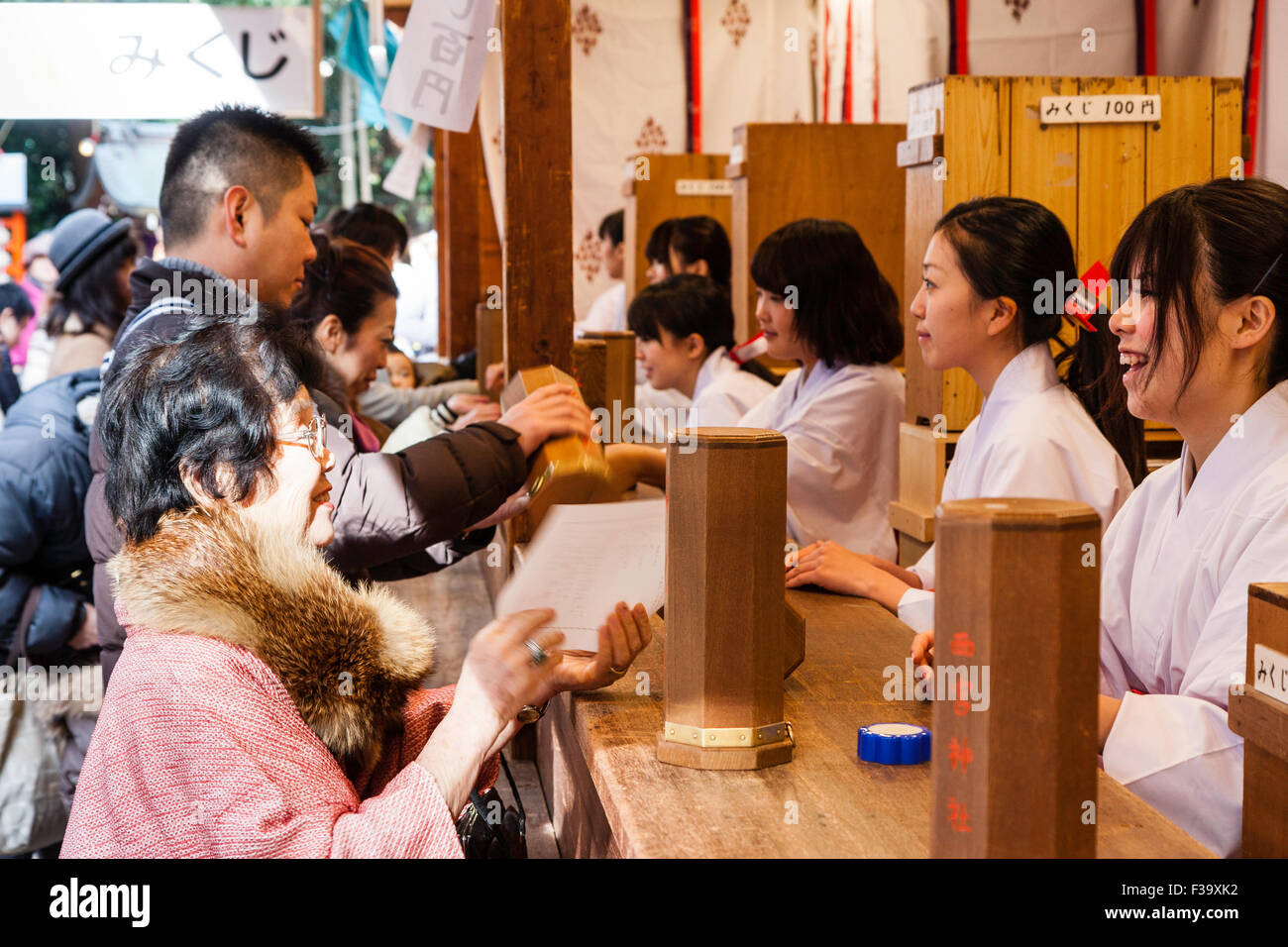 Japan, Nishinomiya shrine, New year Day, Shogatsu. Woman buying omikuji ...