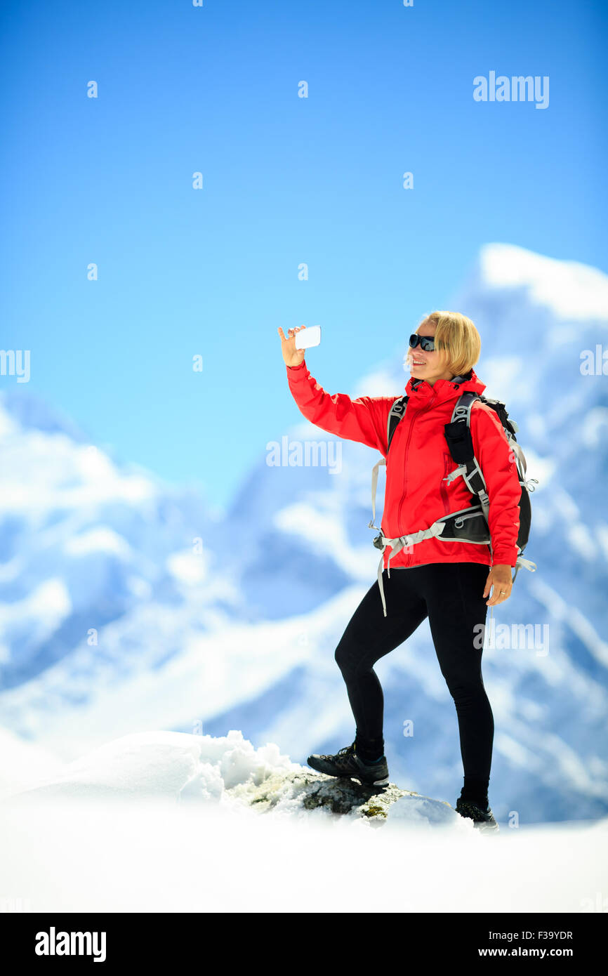 Young happy woman hiker doing selfie self-portrait on mountain peak ...