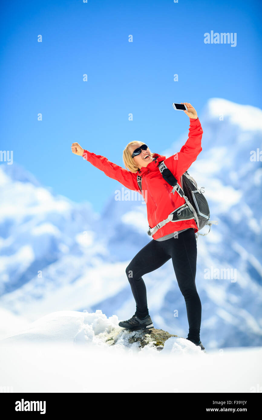 Young happy woman hiker doing smartphone selfie self-portrait on ...