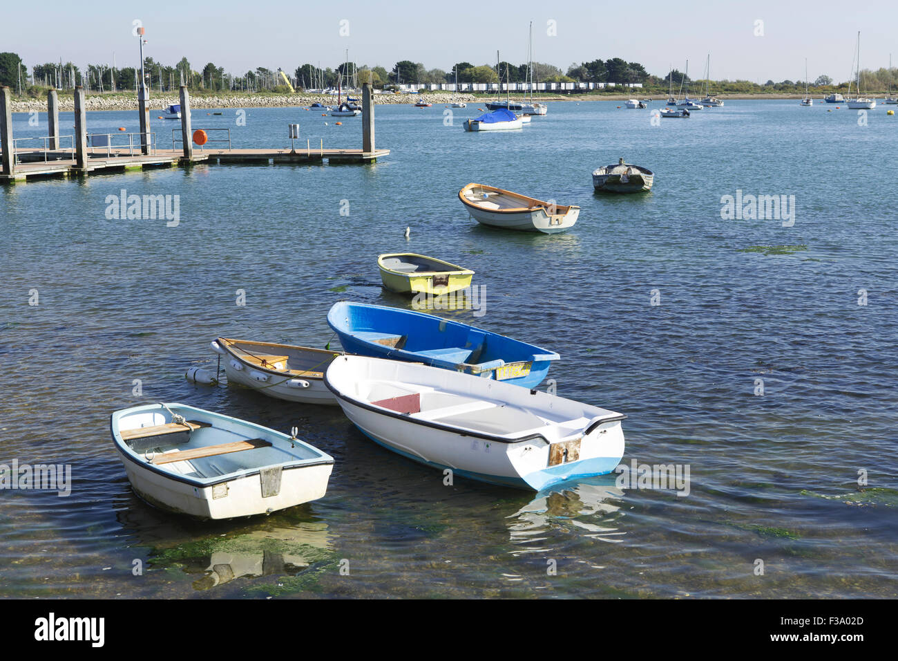 Collection of small boats or tenders in Chichester harbour at Emsworth. Boats forming an informal line front left to rear right. Stock Photo