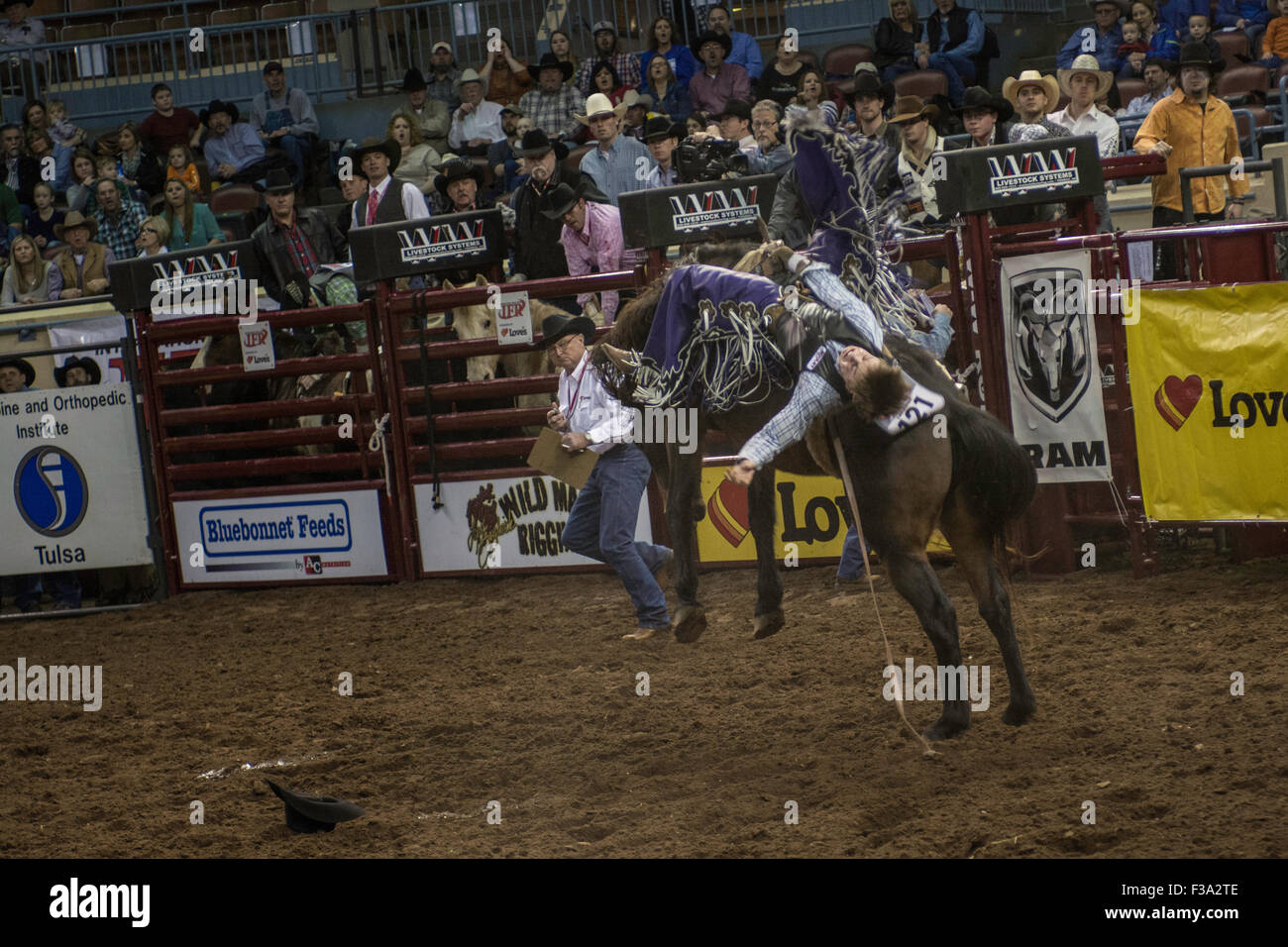 Cowboy riding bucking horse during rodeo in Oklahoma City, Oklahoma