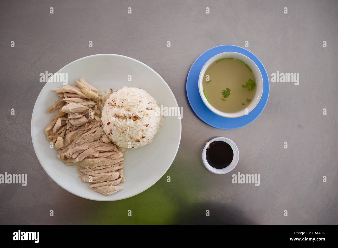 Hainanese chicken rice with broth and black soysauce Stock Photo