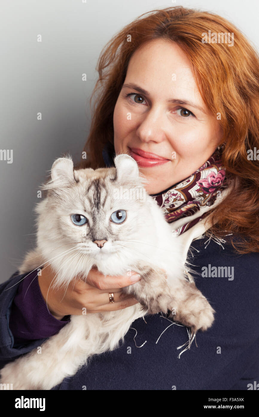Portrait of beautiful smiling Young Caucasian woman with white cat Stock Photo