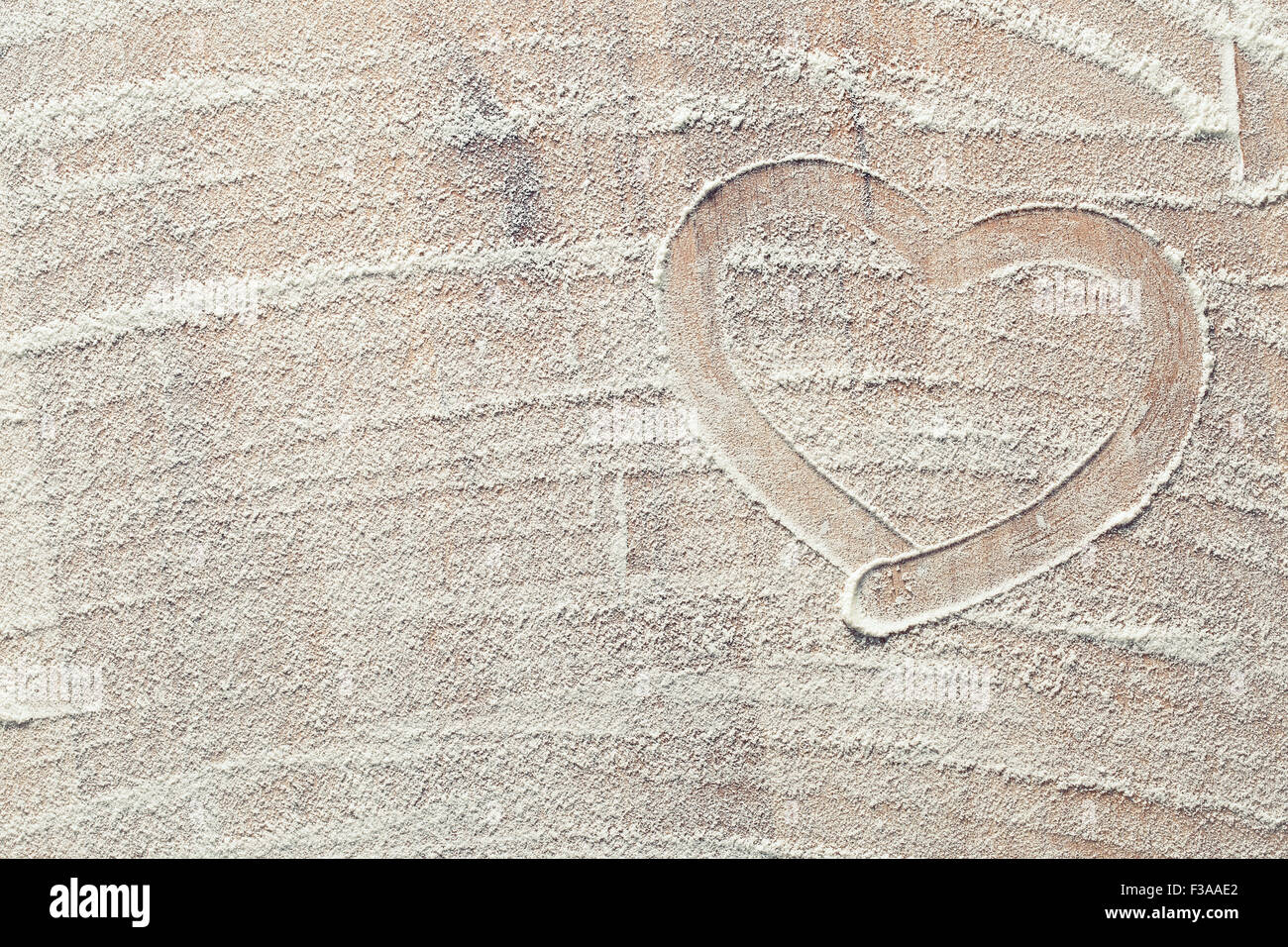 heart made from white flour on kitchen table Stock Photo