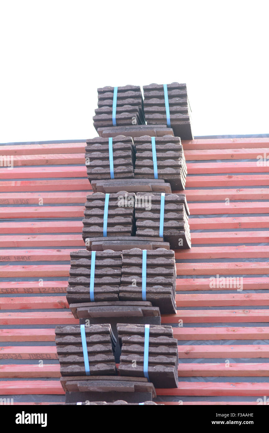 Roof tiles stacked in piles on wooden battens ready for fixing to roof