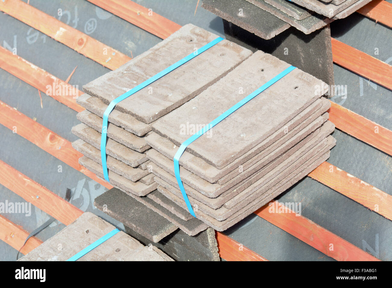 Roof tiles stacked in piles on wooden battens ready for fixing to roof