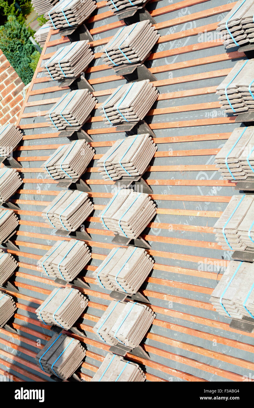 Roof tiles stacked in piles on wooden battens ready for fixing to roof