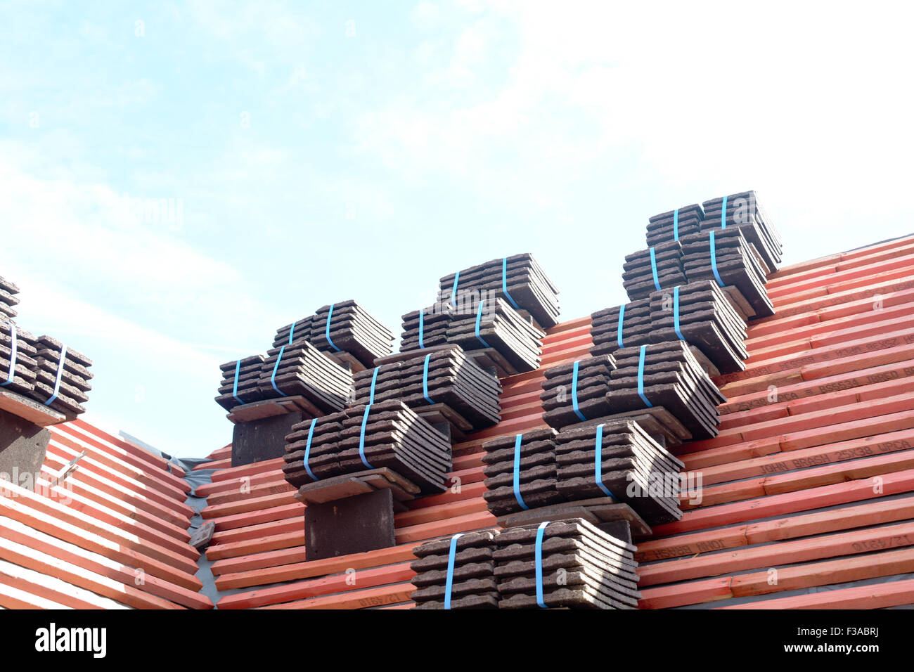 Roof tiles stacked in piles on wooden battens ready for fixing to roof
