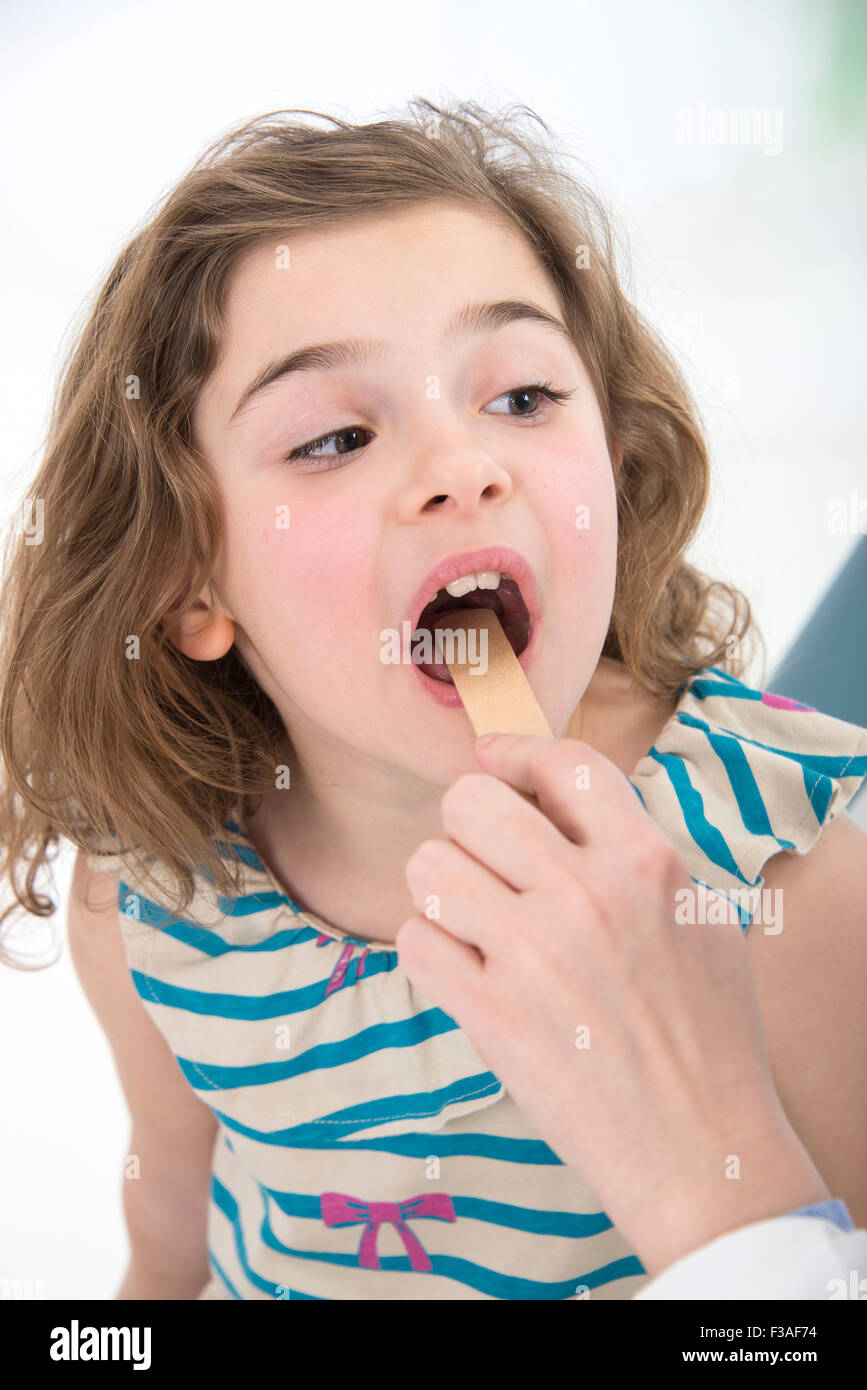 MODEL RELEASED. Young girl with her mouth open being examined by a doctor. Stock Photo