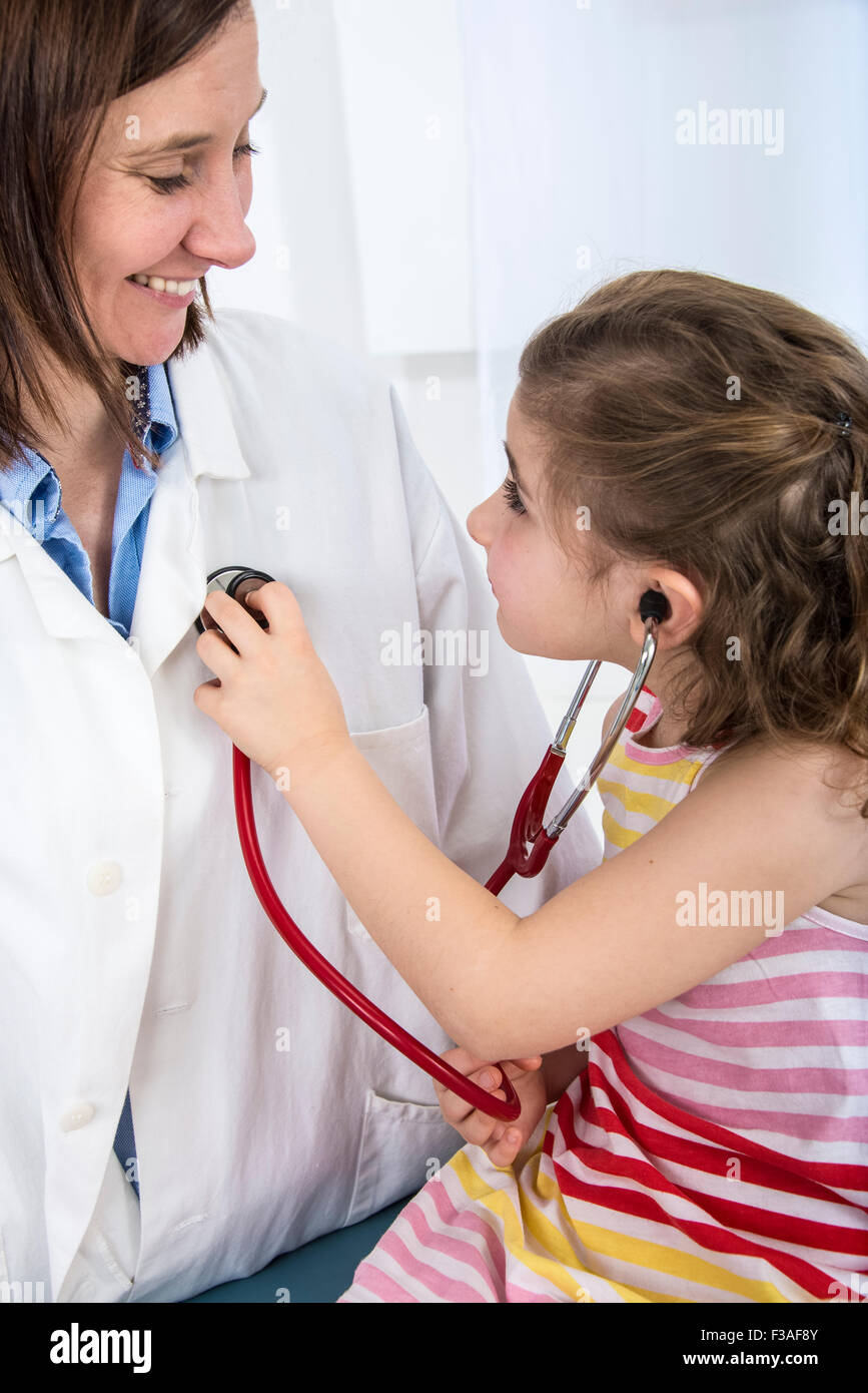MODEL RELEASED. Young girl using a stethoscope on a female doctor Stock ...