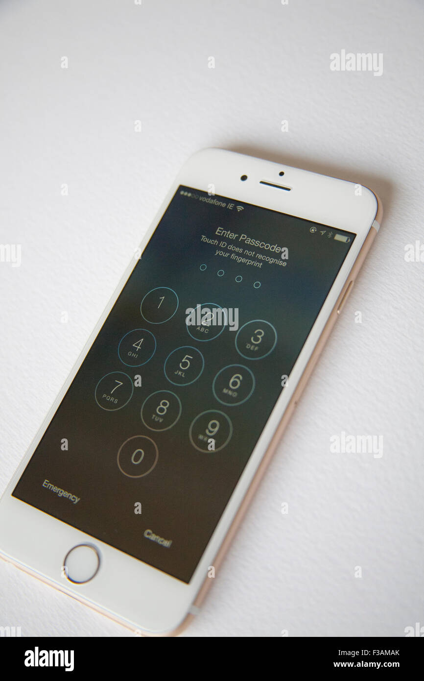 Gold and white Apple iPhone 6 with log in screen to type in password Stock Photo