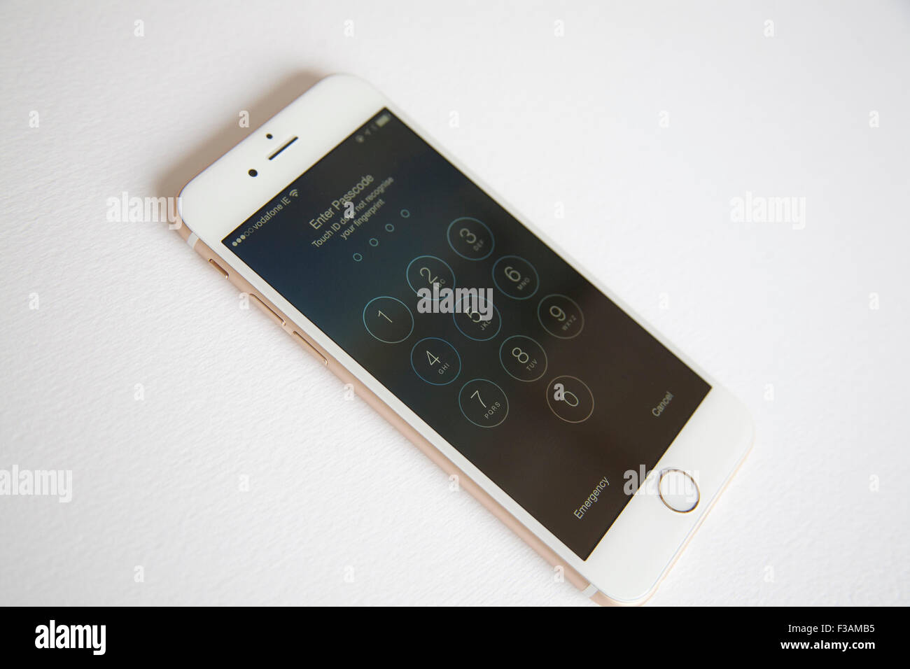 Gold and white Apple iPhone 6 with log in screen to type in password Stock Photo