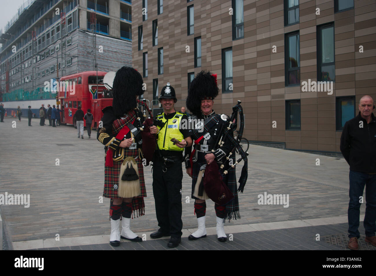 Newcastle upon Tyne, UK. 03 October, 2015. A policeman poses with two pipers outside the Rugby World Cup fanzone at Newcastle before a Scotland match at St James Park.  Credit:  Colin Edwards/Alamy Live News Stock Photo
