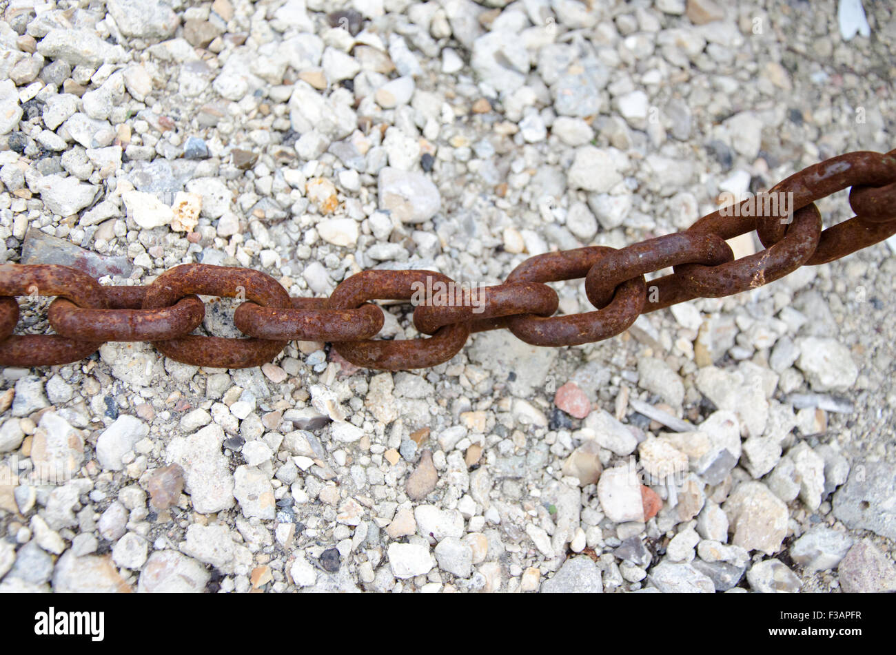 An ancient rusty chain with rocks background Stock Photo - Alamy