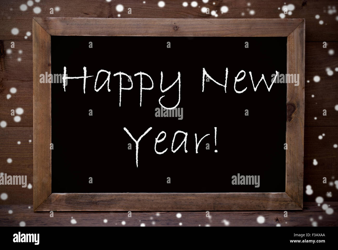 Brown Blackboard With English Text Happy New Year As Greeting Card. Wooden Background. Vintage Rustic Style. Snowflakes Symboliz Stock Photo