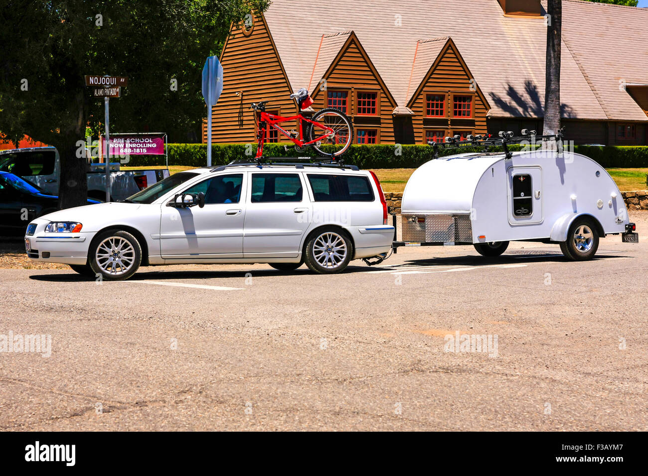 A Volvo V70 station-wagon towing a mini teardrop travel trailer in Los Olivos California Stock Photo