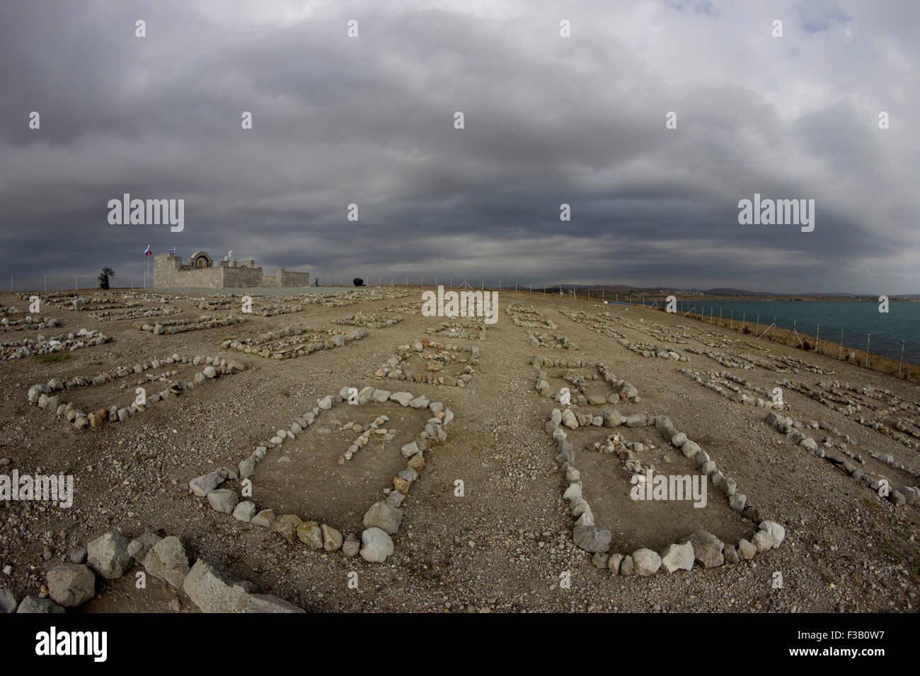 Lemnos island, Greece. 3rd October, 2015. Dramatic early morning wide view of the Russian Civil War memorial and graveyard tombstones, situated on Punta cape, in Koutali village bay, Lemnos island, Greece. Credit:  BasilT/Alamy Live News Stock Photo