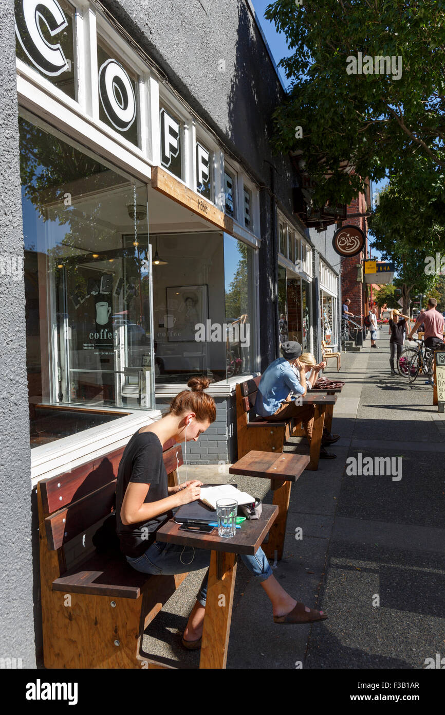 People sitting outside coffee shop reading Victoria British Columbia Stock Photo