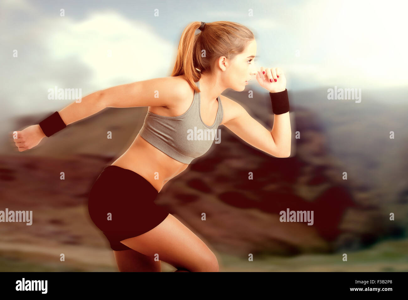 Young fit woman jogging in the nature at sunset Stock Photo