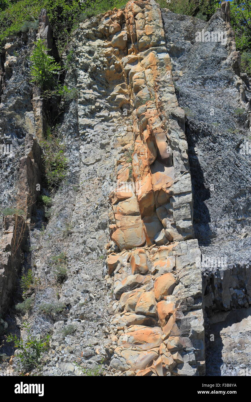 Coastal steep mountain slope with visible rock strata Stock Photo