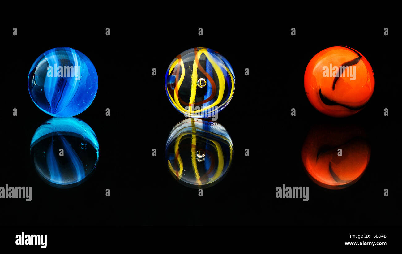 Three marbles and their reflections Stock Photo