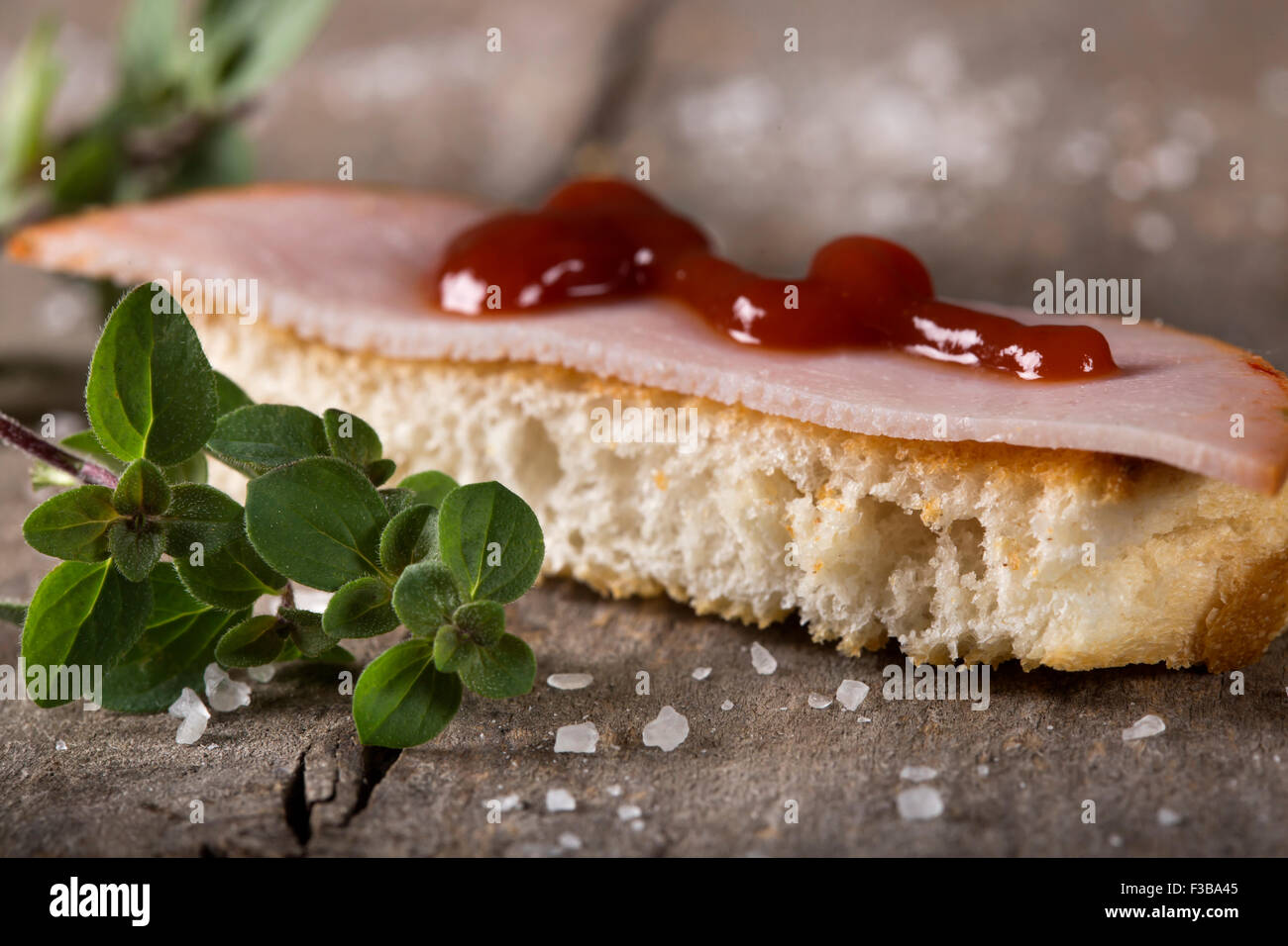 Toasted bread slices with smoked meat over rustic wooden background Stock Photo