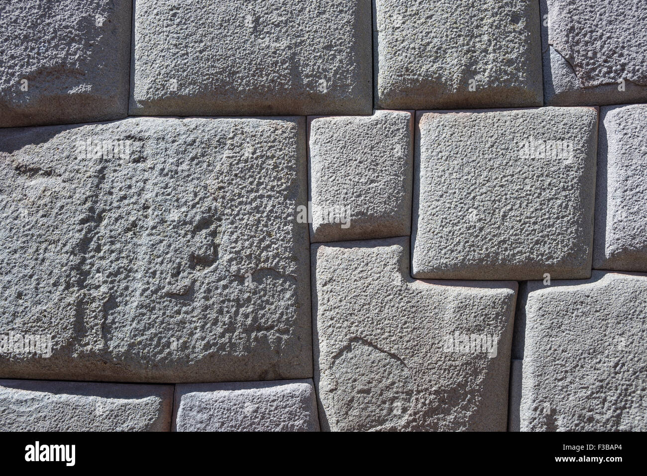 Inca wall made of natural volcanic stones, perfectly shaped, heritage of Inca history and architecture in Cusco, Peru. Backgroun Stock Photo