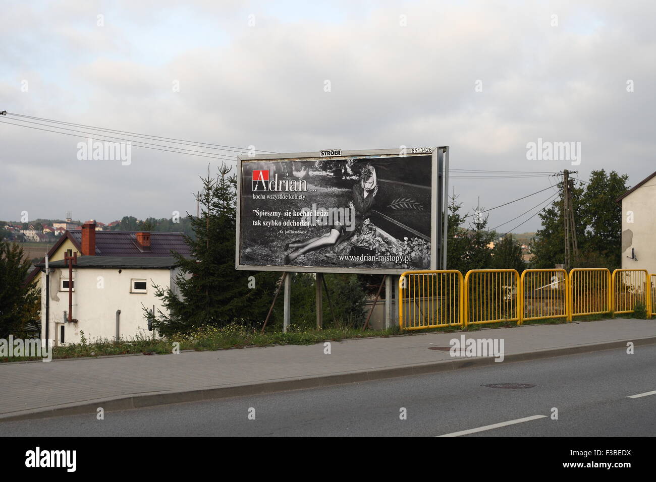 Gdansk, Poland 2nd, Oct. 2015 Controversial banner outdoor campaign of the  Adrian company producing tights. Banner with a picture of woman sitting at  the tomb, and priest Jan Twardowski sentence - '